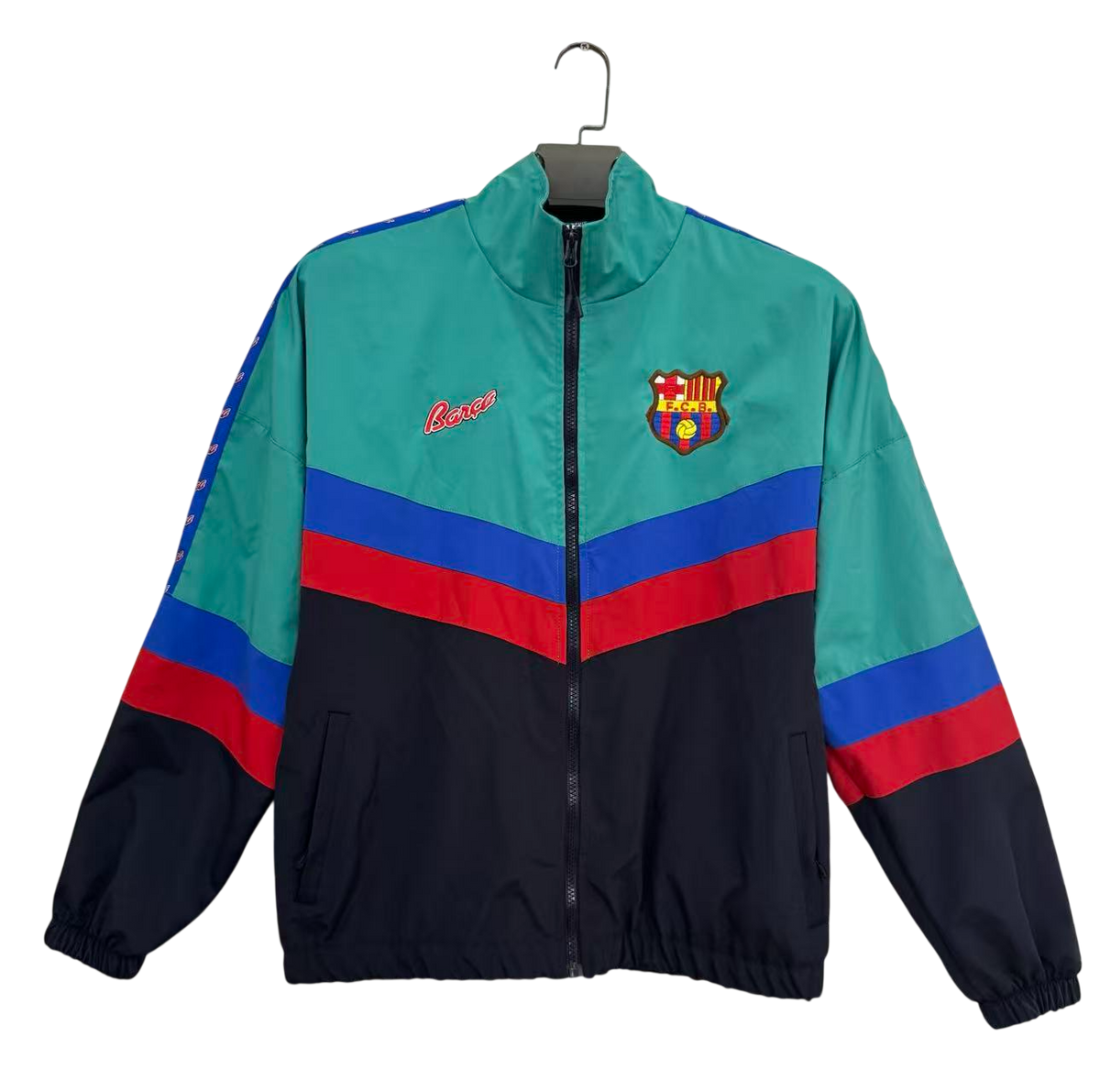 A vintage 1990s FC Barcelona track jacket by Lancer, featuring a teal upper chest and shoulders, a navy lower body and sleeves, and bold red and blue stripe accents across the chest and sleeves. The FC Barcelona crest is embroidered on the left chest, and the Lancer brand name is embroidered in red on the right chest.