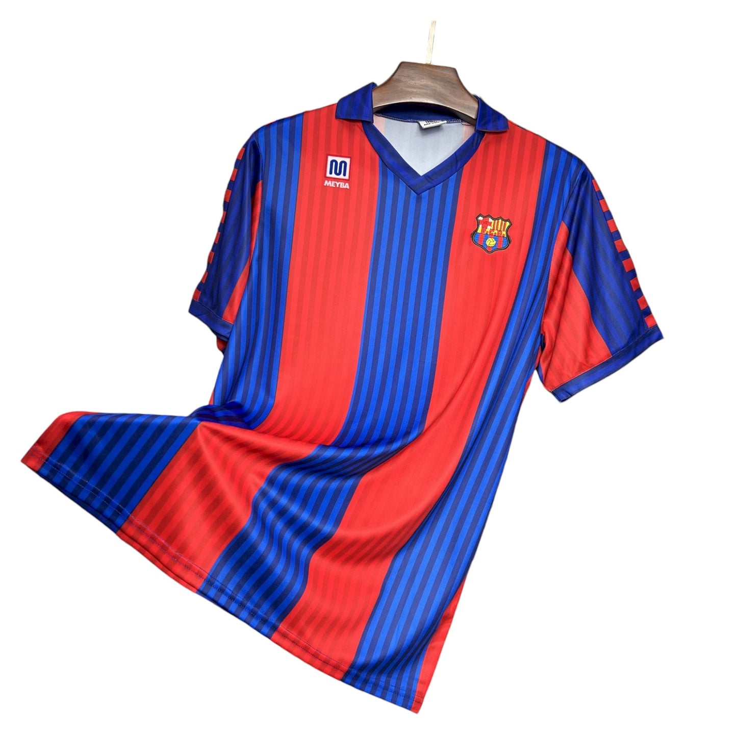 A FC Barcelona 1991/1992 Home Jersey displayed on a hanger, featuring blue and red vertical stripes with the team's crest on the chest.