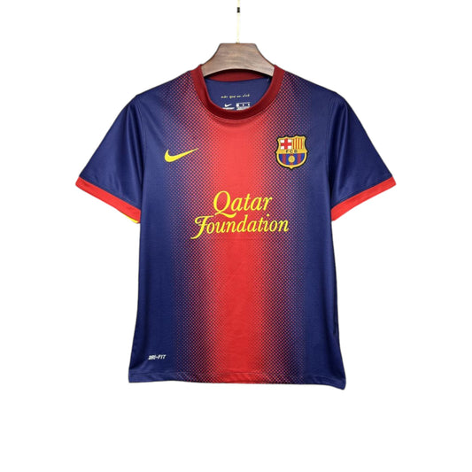 A FC Barcelona 2012/2013 Home Jersey featuring a gradient of red to blue with the club crest and Qatar Foundation sponsorship logo in yellow lettering.